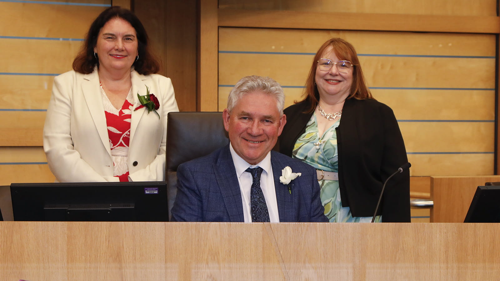 The Presiding Officer sitting at the dais, with the two Deputy Presiding Officers