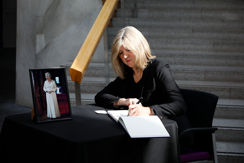 Presiding Officer Alison Johnstone MSP signs the book of condolence in the Garden Lobby of the Scottish Parliament