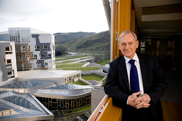 Sir George Reid, Presiding Officer from 7 May 2003 to 14 May 2007, pictured at a window in the MSPs' block with the Parliament behind him. Credit: Harry Benson 