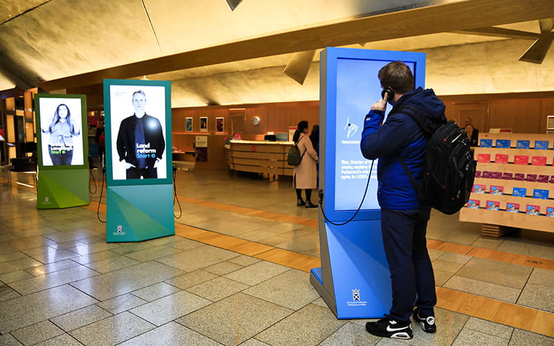 A visitor to the main hall looks at an interactive screen